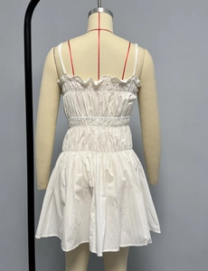 Detailed back view of white summer dress showing smocked elastic waist and ruffle trim