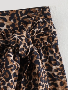 Detailed view of leopard print cotton fabric with knot and pleat textures on mini skirt
