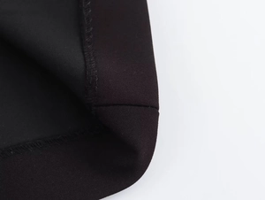 Close-up of high-quality black woven fabric texture and neat stitching on dress hem