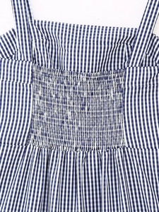Close-up of smocking details on blue and white gingham embroidery dress with fine stitching