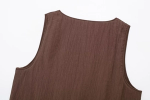 Detail shot of dark brown textured sleeveless top showing neck and pleated fabric
