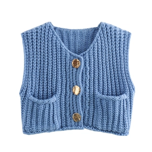 Close-up detail of blue chunky knit vest with V-neck, gold buttons and patch pockets