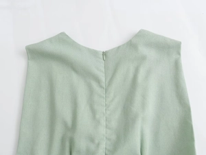 Detailed view of sage green dress back featuring a hidden zipper and woven texture