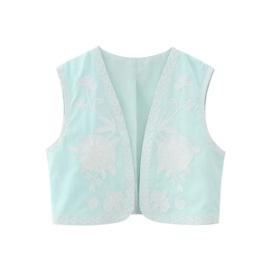 Détail du gilet ethnique vert menthe avec broderie florale blanche et bordure en dentelle
