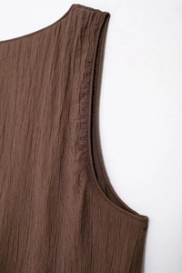 Detailed macro shot showing the fine vertical pleated texture of a coffee-colored sleeveless top