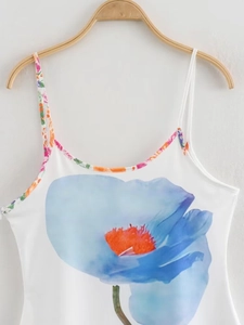 Detail of white camisole top featuring blue floral print and colorful floral trim piping
