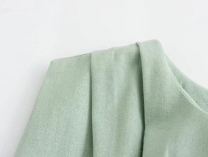 Detailed macro view of light green breathable fabric with visible textured weave and stitching
