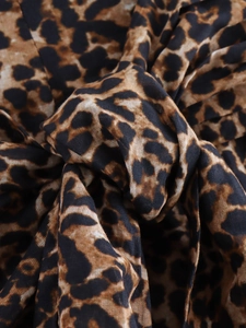 Close-up of lightweight leopard print cotton fabric with detailed animal pattern texture