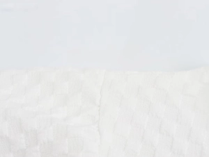 Macro shot of white seersucker fabric texture with textured checkered weaving patterns