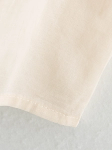 Detailed macro view of the beige midi dress showing fine plain weave fabric and stitching