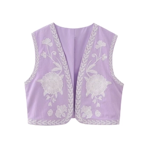 Détail de la broderie florale blanche et texture ondulée sur le gilet lavande