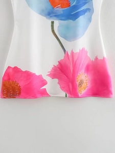 Detail of vibrant pink and blue floral print on white summer dress fabric texture