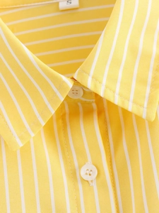 Macro detail of the yellow striped cotton shirt collar with size S tag and white buttons