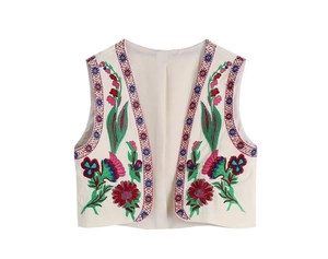 Vue détaillée de la broderie florale colorée sur un gilet ethnique ivoire