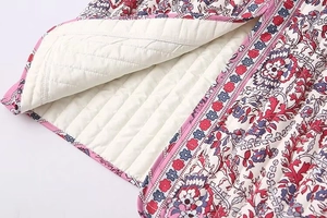 Close-up of ethnic floral quilted vest with horizontal stitching and white lining texture