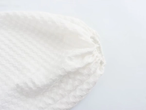 Detailed close-up of white bubble sleeves with waffle jacquard texture and elastic cuffs