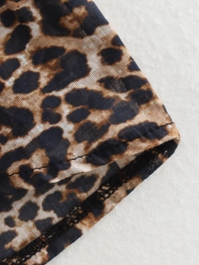 Macro shot showing leopard print fabric texture and high-quality hem stitching details