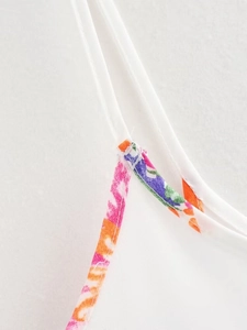 Close-up of stitching details and floral print fabric on the thin shoulder strap