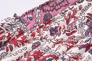 Close-up of ethnic floral print on quilted fabric vest with detailed stitching texture