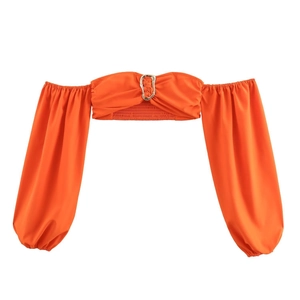 Vibrant orange crop top with lantern sleeves and central metal ring detail on white background