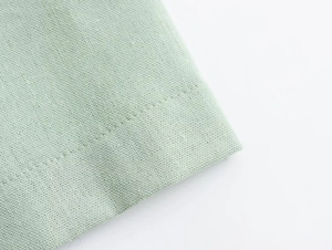 Detailed macro shot of mint green fabric showing premium stitching and woven texture