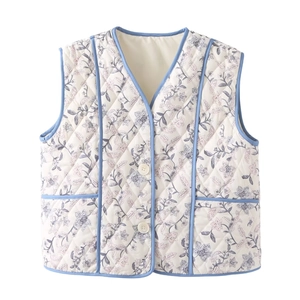 Detail of floral quilted vest showing blue piping, front buttons and hand pockets