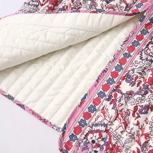 Detail of ethnic floral print quilted cotton vest featuring contrast lining and neat piping