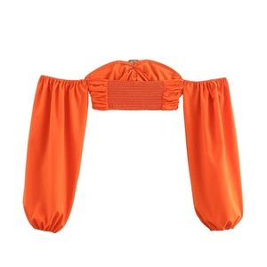Detail of crop top back with smocking design and orange woven fabric texture