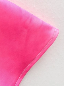 Close-up of pink fabric detail with precise white double stitching on a high-quality dress