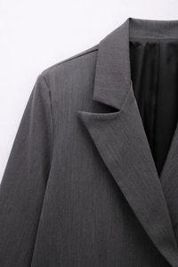 Close-up of notched lapels and structured shoulders on a dark grey double-breasted blazer