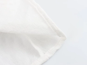 Close-up of white puff sleeve cuff showing premium stitching and cotton-linen texture