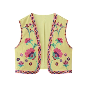 Détail de la broderie florale et du ruban ethnique sur un gilet jaune bohème