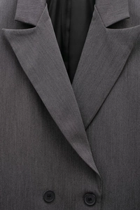 Detail of classic notch lapel and double-breasted buttons on dark grey blazer jacket