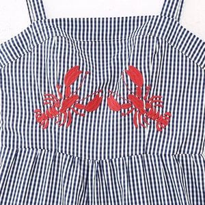 Blue gingham summer dress featuring detailed red lobster embroidery on the bodice