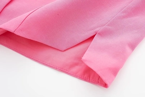 Detail of hot pink linen fabric with precise stitching and diagonal twill texture