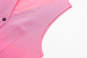 Detail of pink linen vest showing high-quality woven fabric and black button closure