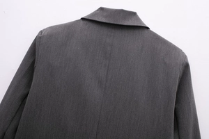 Detailed view of dark grey blazer collar and shoulder tailoring with twill fabric texture