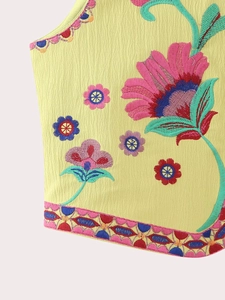 Détail de la broderie florale et de la texture froissée sur un gilet bohème