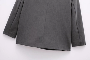 Detailed view of the back hem and vertical stitching on this dark grey women blazer