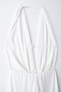 Detail of white halter neck dress featuring open back design and silver metal T-buckle