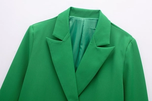 Close-up of bright green women's blazer featuring notched lapels and fine fabric texture