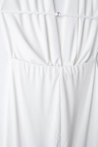 Detail of white pleated dress showing fabric texture and adjustable strap with metal buckle