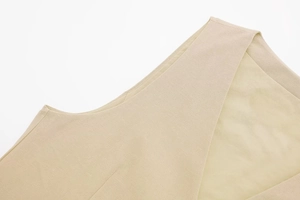 Detailed view of beige linen vest neckline and shoulder showing precise stitching and fabric texture