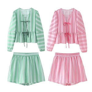 Close-up of women's striped long sleeve sets featuring front ties and ruffle hem details