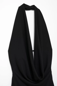 Detail view of black cowl neck halter dress featuring elegant pleated plunging V-neckline