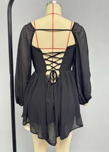Close-up of the back cross lacing and hollow-out design on a black chiffon V-neck dress