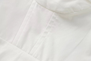 Close-up of fine double-needle stitching and fabric texture on white corset top