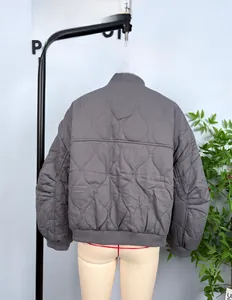 Detail of dark grey quilted bomber jacket featuring wavy stitching and ribbed cuffs