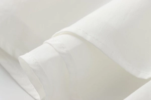 Close-up of white fabric texture showing detailed stitching on the corset strap