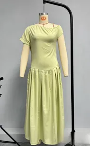 Détail de la robe longue plissée vert clair à épaule dénudée sur un mannequin de studio
